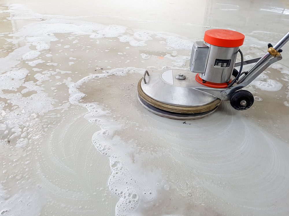 Polished concrete being cleaned with a floor scrubber.